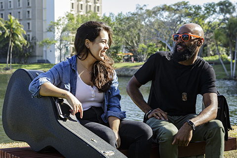 Two students relaxing during a break by Lake Osceola at the University of Miami Coral Gables campus